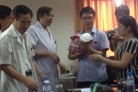 Bé Gấu đã về trong vòng tay của bố. (Ảnh: PV/Vietnam+)