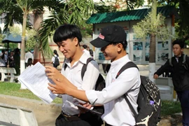 Các thí sinh tập trung trao đổi kết quả sau khi rời khỏi phòng thi trong. (Ảnh: Phan Sáu/TTXVN)