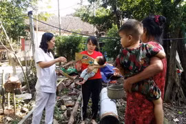 Cán bộ y tế hướng dẫn người dân vệ sinh cá nhân phòng chống dịch bệnh. (Ảnh: TTXVN)