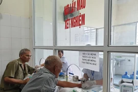 Lấy máu xét nghiệm cho bệnh nhân. (Ảnh: PV/Vietnam+)
