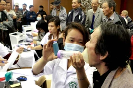 Nhân viên y tế hướng dẫn người dân khám phát hiện bệnh phổi tắc nghẽn mạn tính. (Ảnh: TTXVN)