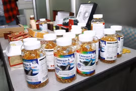 Lực lượng chức năng thu giữ các sản phẩm thực phẩm chức năng không rõ nguồn gốc. (Ảnh: TTXVN/Vietnam+)