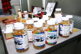 Lực lượng chức năng thu giữ các sản phẩm thực phẩm chức năng không rõ nguồn gốc. (Ảnh: TTXVN/Vietnam+)