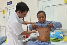 Bác sỹ Nguyễn Đức Tuyến thăm khám cho bệnh nhân Siêng Bun Thăn. (Ảnh: T.G/Vietnam+)