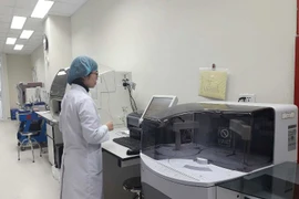 Nhân viên y tế vận hành máy móc tại Phòng xét nghiệm tham chiếu về kháng kháng sinh. (Ảnh: PV/Vietnam+)