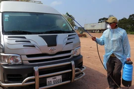 Phun thuốc khử trùng với xe ôtô đi qua cửa khẩu quốc tế La Lay (Quảng Trị) giáp Lào. (Ảnh: Trần Tĩnh/TTXVN)