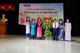 Phó Tổng giám đốc Thông tấn xã Việt Nam Đinh Đăng Quang tặng hoa chúc mừng Ban Nữ công cơ quan TTXVN. (Ảnh: Quang Quyết/TTXVN)