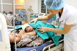 Chăm sóc sơ sinh sau ca đẻ tại bệnh viện. (Ảnh: Dương Ngọc/TTXVN)