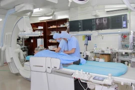 Ê-kíp thực hiện gây mê chuẩn bị chụp mạch máu não cho một bệnh nhân. (Ảnh: Đặng Tuấn/TTXVN)