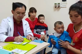 Bác sỹ Bệnh viện Hữu nghị Việt Nam Cu Ba khám cho trẻ em dị tật hàm mặt. (Ảnh: PV/Vietnam+)