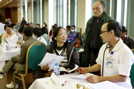 Các bác sỹ Bệnh viện Bạch Mai khám chữa bệnh cho bệnh nhân. (Ảnh: Dương Ngọc/TTXVN)