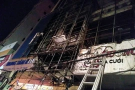 Ngọn lửa thiêu rụi phần trên của 2 ngôi nhà. (Ảnh: Nguyễn Nam/TTXVN)