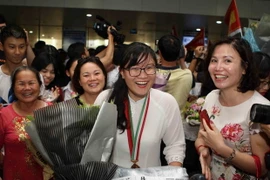 Em Nguyễn Phương Thảo, Trường THPT chuyên Khoa học Tự nhiên, Đại học Quốc gia Hà Nội, trong sự chào đón của người thân và bè bạn. (Ảnh: Thanh Tùng/TTXVN)