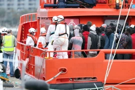 Lực lượng phòng vệ dân sự Tây Ban Nha hỗ trợ người di cư tại cảng Arguineguin, đảo Canary ngày 18/6 vừa qua. (Ảnh: EPA-EFE/TTXVN)