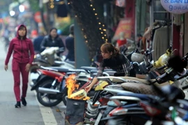 Nhiều gia đình đã làm cỗ và đốt vàng mã tiễn các Táo quân về chầu trời sớm trước một ngày. (Ảnh: Trọng Đạt/TTXVN)