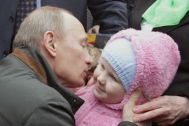 Thủ tướng Nga Vladimir Putin hôn một em bé ở St. Petersburg. (Nguồn: AFP/Getty Images)
