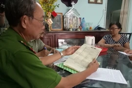 Cảnh sát khu vực hướng dẫn người dân kê khai thông tin cá nhân. (Ảnh: Thành Chung/TTXVN)