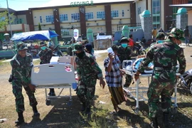 Binh sỹ Indonesia chuyển nạn nhân bị thương sau trận động đất tới lều cấp cứu tạm thời ở Lombok ngày 7/8. (Ảnh: THX/TTXVN)