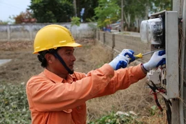 Nhân viên Công ty Điện lực huyện Chương Mỹ lắp đặt thay mới công tơ cho một số hộ dân có công tơ bị ngập nước, hư hỏng tại xã Nam Phương Tiến, huyện Chương Mỹ, Hà Nội. (Ảnh Mạnh Khánh/TTXVN)