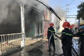 Lực lượng chức năng nỗ lực dập tắt đám cháy. (Ảnh: Nguyễn Văn Việt/TTXVN)