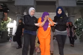 Cảnh sát áp giải cựu Cục trưởng Cục tình báo nước ngoài Malaysia Hasanah Abdul Hamid (giữa) tới tòa án Putrajaya Magistrate. (Ảnh: NST/TTXVN)
