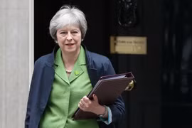 Thủ tướng Anh Theresa May rời khỏi tòa nhà Chính phủ để tới phiên họp Quốc hội ở London ngày 12/6 vừa qua. (Ảnh: AFP/TTXVN)