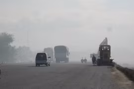 Các phương tiện tham gia giao thông trong khói bụi. (Ảnh: Công Thử/TTXVN)