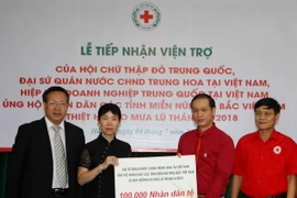 Bà Doãn Thái Hồng đại biện lâm thời Đại sứ quán Trung Quốc tại Việt Nam trao tượng trưng số tiền ủng hộ nhân dân các tỉnh miền núi phía Bắc khắc phục hậu quả mưa lũ. (Ảnh: Thanh Tùng/TTXVN)