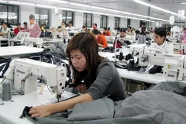 Công nhân sản xuất đồ may mặc. (Ảnh: Phạm Kiên/TTXVN)
