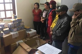 Công an giao thông tỉnh Đắk Lắk lập biên bản tịch thu tang vật (gồm pháo và thuốc lá lậu) thu giữ từ các xe khách. (Ảnh: Phạm Cường/TTXVN)