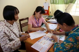 Người dân đăng ký tham gia bảo hiểm xã hội, bảo hiểm y tế tại phường Noong Bua, thành phố Điện Biên Phủ. (Ảnh: Phan Tuấn Anh/TTXVN)