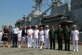 Thượng tá Nguyễn Ngọc Anh, Phó lữ đoàn trưởng Lữ đoàn 125 Hải quân Việt Nam với Trung tá Lisa Hunn, chỉ huy tàu Hải quân Hoàng gia New Zealand HMNZS Te Mana F77 cùng các đại biểu tại cảng Sài Gòn. (Ảnh: Thanh Vũ/TTXVN)