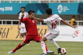 Pha tranh bóng giữa Quang Hải và cầu thủ Olympic UAE. (Ảnh Hoàng Linh/TTXVN) 