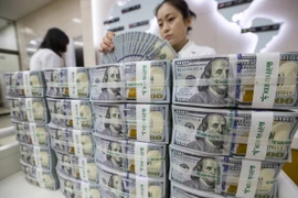 Kiểm tiền USD tại ngân hàng Hana ở thủ đô Seoul, Hàn Quốc ngày 4/7 vừa qua. (Ảnh: EPA-EFE/TTXVN)