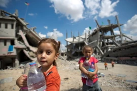 Trẻ em Palestine trữ nước sinh hoạt tại khu vực lân cận Dải Gaza Shejaiya. (Ảnh: AFP/TTXVN)