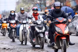 Trang phục kín mít của người dân khi ra đường để tránh rét. (Ảnh: Quang Quyết/TTXVN)