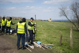 Các chuyên gia Hà Lan và Malaysia làm nhiệm vụ tại khu vực rơi máy bay MH17 ngày 23/4. (Nguồn: AFP/TTXVN)