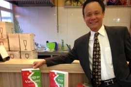 Tác giả Trần Đình Kiêm cùng bộ từ điển của ông. (Ảnh: Trần Hà Anh/Vietnam+)