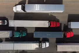 Các phương tiện vận chuyển hàng hóa từ Mexico vào Mỹ chờ tại cảng thương mại ở Otay, Tijuana (Mexico). (Ảnh: AFP/TTXVN)