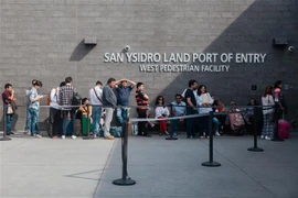 Người di cư xếp hàng tại cửa khẩu San Ysidro giữa Tijuana, Mexico, và San Diego, California, Mỹ. (Ảnh: AFP/TTXVN)