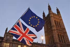 Cờ Anh (phía dưới) và cờ EU (phía trên) tại thủ đô London, Anh. (Ảnh: AFP/TTXVN)
