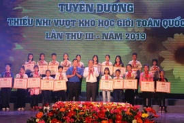 Phó Thủ tướng Thường trực Chính phủ Trương Hòa Bình, anh Lê Quốc Phong, Bí thư thứ nhất Trung ương Đoàn trao tặng Bằng khen của Trung ương Đoàn cho thiếu nhi vượt khó học giỏi tiêu biểu. (Ảnh: Xuân Dự/TTXVN)