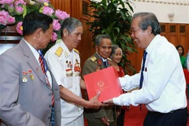 Phó Thủ tướng Thường trực Chính phủ Trương Hòa Bình tặng quà lưu niệm cho các đại biểu người có công tỉnh Kon Tum. (Ảnh: Doãn Tấn/TTXVN)