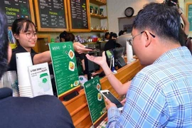 Nhiều hệ thống nhà hàng, cửa hàng chấp nhận thanh toán không dùng tiền mặt qua Ví điện tử MoMo. (Ảnh: TTXVN phát)