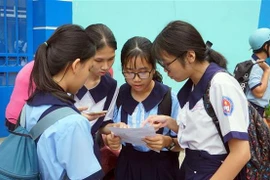 Thí sinh tại điểm thi Trường Trung học cơ sở Lê Lợi (quận 3) trao đổi bài sau giờ thi. (Ảnh: Thu Hoài/TTXVN)