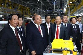Thủ tướng Nguyễn Xuân Phúc và các đại biểu thăm xưởng lắp ráp Nhà máy sản xuất ôtô Vinfast. (Ảnh: Thống Nhất/TTXVN)