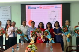 Đại diện Liên hiệp các Hội văn học nghệ thuật thành phố và Nhà xuất bản Văn hóa nghệ thuật tặng hoa cho các tác giả. (Ảnh: Gia Thuận/TTXVN)
