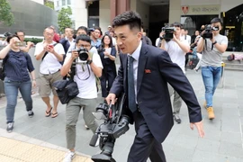 Phóng viên Triều Tiên (giữa) đưa tin về cuộc gặp thượng đỉnh Mỹ-Triều tại trung tâm báo chí ở Vịnh Marina, Singapore ngày 10/6. (Nguồn: Yonhap/TTXVN)