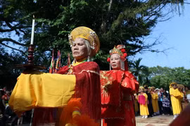 Nghi thức tế lễ bắt đầu khi một nữ quan dẫn chủ tế vào thắp hương trong đền. (Ảnh: Phan Tuấn Anh/TTXVN)