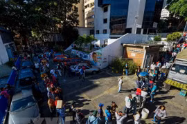 Người dân Venezuela xếp hàng chờ đổi tiền bên ngoài ngân hàng trung ương ở Caracas. (Nguồn: AFP/TTXVN)